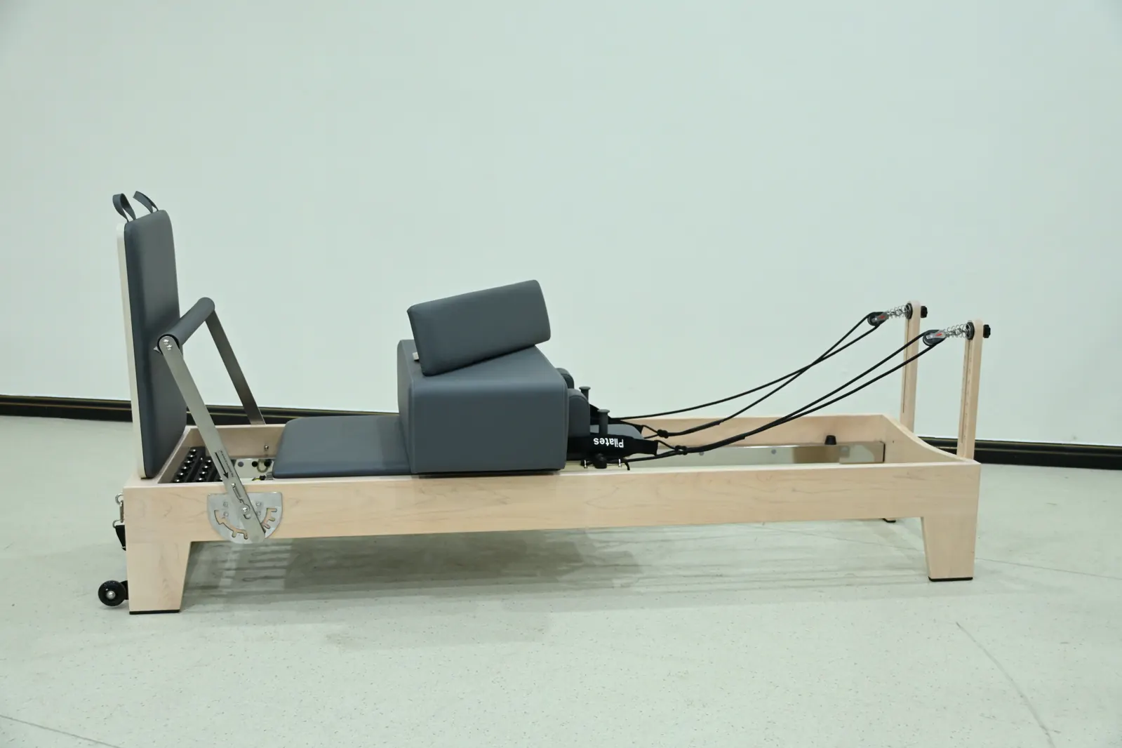 Reformer Pilates à châssis en bois présenté pour un projet de studio